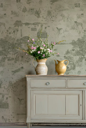 Dog Tales wallpaper by Victoria Sanders in green, a toile of dogs in the countryside above a sideboard