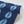 Indigo Nui wallpaper by Tatie Lou in indigo blue, partly unrolled roll showing nui shibori dots