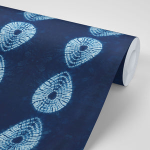 Indigo Nui wallpaper by Tatie Lou in indigo blue, partly unrolled roll showing nui shibori dots