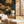 Whispers of Peony wallpaper by Dami and Em Design in gold, peonies behind a bed