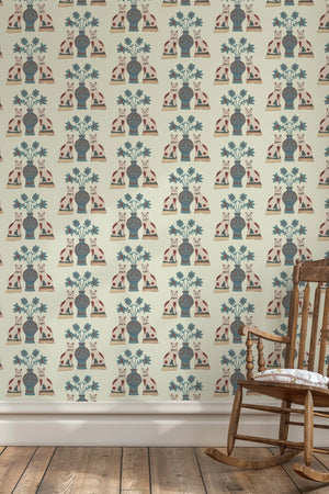 Pair of Cats wallpaper by Annika Reed in blue and cream, pairs of cats and vases behind a sofa in a living room