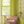 Bel Air Blossom wallpaper by Liberty James Studio in yellow-green, a mirrored blossom design behind a sofa in a living room