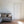 Caja Floral wallpaper by Seed Home Designs in grey, line-drawn daisies behind a sofa in a living room