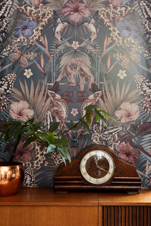 Exotica wallpaper by Victoria Sanders in petrol blue, jungle animals and tropical flowers behind a console table