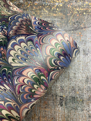 Serpentine wallpaper by House of Amitié in pink and blue, roll showing peacock-feather marbling