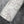 Flourish wallpaper by House of Amitié in silver, roll showing flowing scrolls
