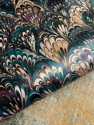 Serpentine wallpaper by House of Amitié in blue and black, sample roll showing peacock-feather marbling
