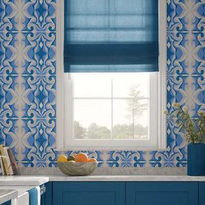 Marco Island wallpaper by Liberty James Studio in blue, a scrolling damask design behind a bed