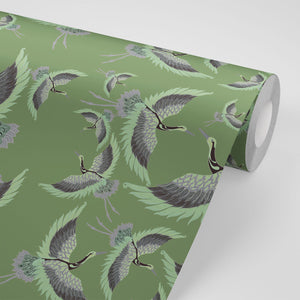 Pachamama wallpaper by Tatie Lou in olive, partly unrolled roll showing flying cranes
