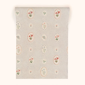 Bibury Sprig wallpaper by Parker and Jules in pale blue, partly unrolled roll showing flower sprigs in ovals