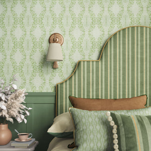 Clover Garden grasscloth by Dami and Em Design in light green, a trailing clover motif behind a headboard in a bedroom