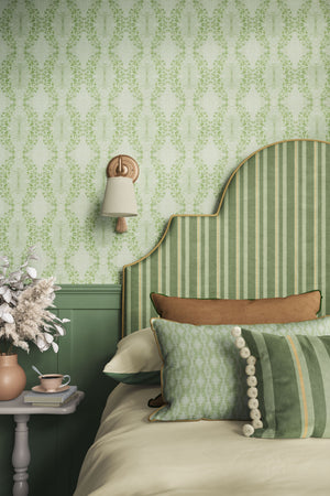 Clover Garden grasscloth by Dami and Em Design in light green, a trailing clover motif behind a headboard in a bedroom
