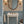 Charlotte Curate Space wallpaper in light cream, hand-painted seashells and starfish in a powder room with a pedestal basin and blue panelling