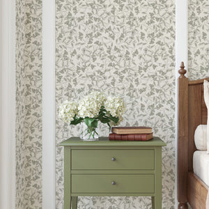 Elena wallpaper by Curate Space in light green, fine linear floral vines in a bedroom with a green bedside table