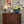 Etta wallpaper by Curate Space in navy, small floral sprigs behind a wooden chest of drawers on a staircase landing