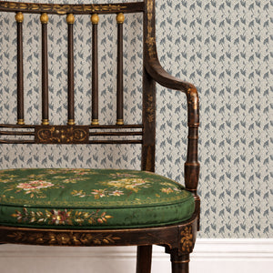 Etta wallpaper by Curate Space in navy, small floral sprigs behind a gilt chair with a green floral seat
