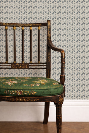 Etta wallpaper by Curate Space in navy, small floral sprigs behind a gilt chair with a green floral seat