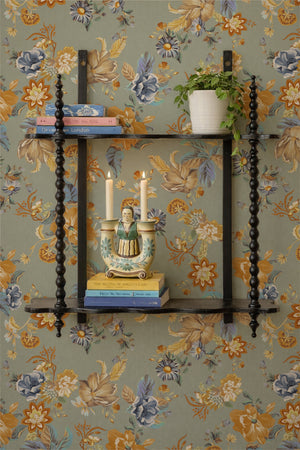 Lottie wallpaper by Curate Space in light blue, oversized chintz-style florals behind black spindle shelves with candlesticks