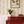 Olive wallpaper by Curate Space in light cream, vertical stripes of botanical stems and wildflowers behind a red chest of drawers and framed botanical print
