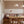 Paloma wallpaper by Curate Space in dark pink, trailing floral stems above panelling in a dining nook with a banquette