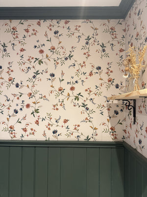 Paloma wallpaper by Curate Space in off-white, trailing floral stems in a hallway above deep green panelling