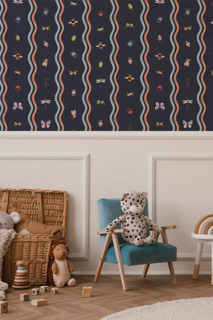 Ren wallpaper by Curate Space in midnight blue, wavy stripes with bugs and butterflies in a nursery with a wicker basket and armchair