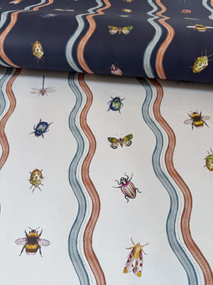 Ren wallpaper by Curate Space in off-white and midnight blue, wavy stripes with bugs and butterflies, rolls in off-white and midnight shown together