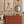 Ren wallpaper by Curate Space in off-white, wavy stripes with bugs and butterflies in a children's room with an orange chest and framed prints