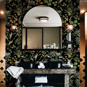Eden wallpaper by Deus ex Gardenia in black, lush leaves and fruit in a bathroom