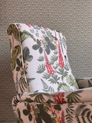 Folly wallpaper by Parker and Jules in beige, small sunburst medallions upholstered on an armchair