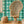 Motif wallpaper by Tatie Lou in green, geometric pyramids in a living room