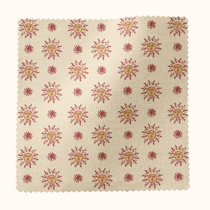 Sunshine Masquerade linen by Annika Reed in cream and red, flat sample of sun and mask motifs