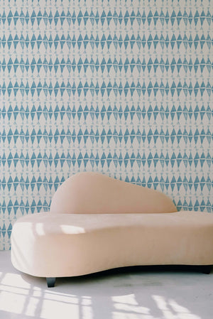 Triangles Wallpaper in Aegean behind a sofa
