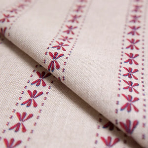Wild Flower linen by Bethie Tricks in red and blue, in soft folds showing the dragonfly-like motif stripes